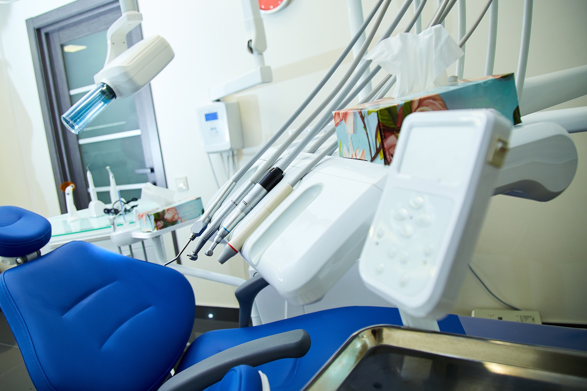 Modern metallic dentist tools and burnishers on a dentist chair
